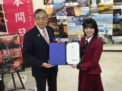 交付された委嘱状を掲げる高橋市長と本間日陽さん