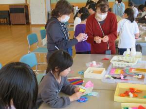 令和7年5月ロング昼休み　子供らと一緒に折り紙を折る大人